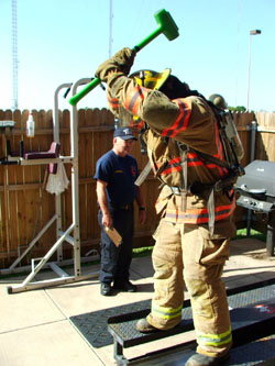 Taking a swing at the I-beam with the hammer.