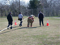 Fire fighter pulling empty hose to the target area.