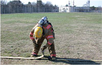 Fire fighter examines the hose connections.